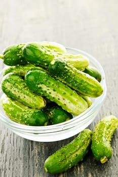 Fresh green pickling cucumbers in a glass bowl