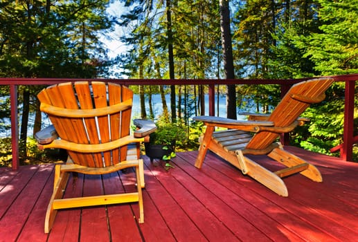 Wooden deck at forest cottage with Adirondack chairs