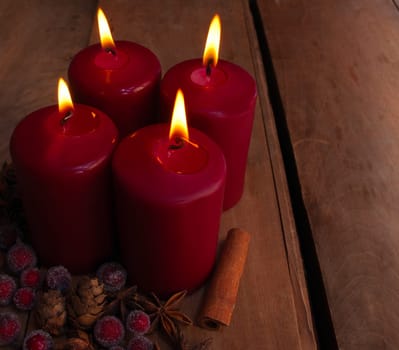 Burning Red Christmas Candles With Decorations on Old Wooden Table