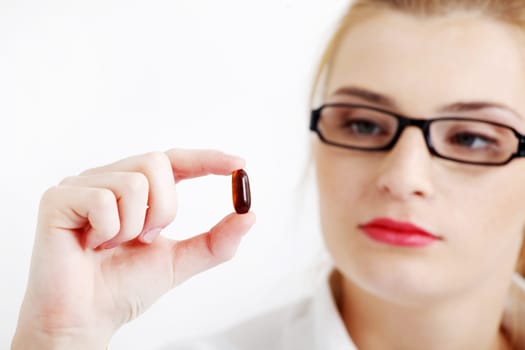 Closeup on young pretty girl`s hand with the pill.