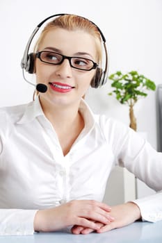 Beautiful caucasian woman with headset sitting in the office.