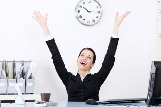 Beautiful caucasian smiling  businesswoman sitting in the office with hands in the air.