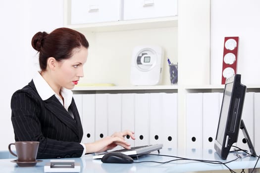 Pretty caucasian businesswoman working on the computer in the office.