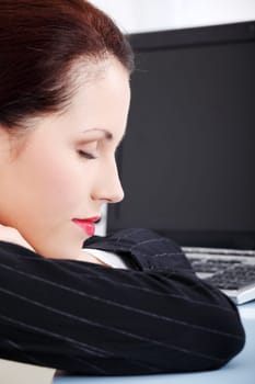 Beautiful caucasian businesswoman dreaming on the desk in the office.