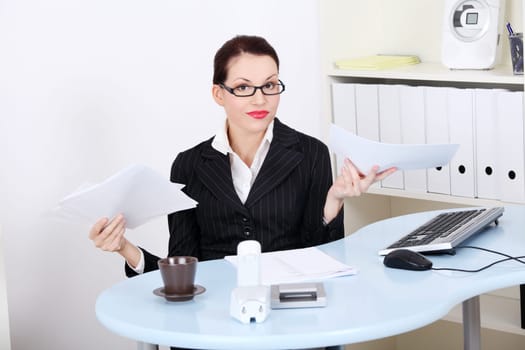 Beautiful caucasian businesswoman having a lot of paperwork in the office.