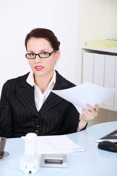 Beautiful caucasian sitting businesswoman holding papers in the office.