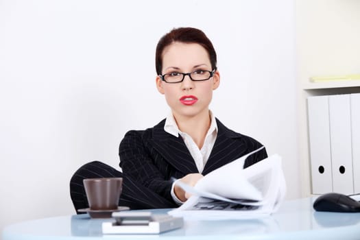 Pretty caucasian mad businesswoman sitting in the office showing files.