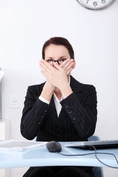 Pretty caucasian businesswoman covering her face with her palms.