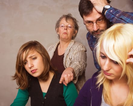 Two teenager girls doing their homework together with their parents