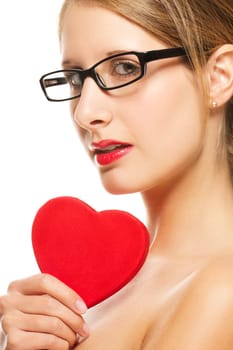 Young woman in black glasses holding red heart on white background