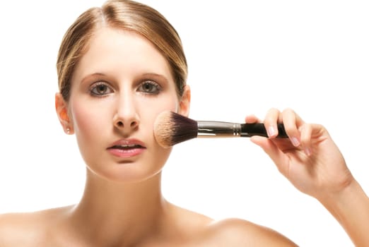 Young woman applying makeup on white background
