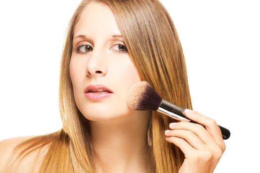 Young woman with brush applying powder on white background