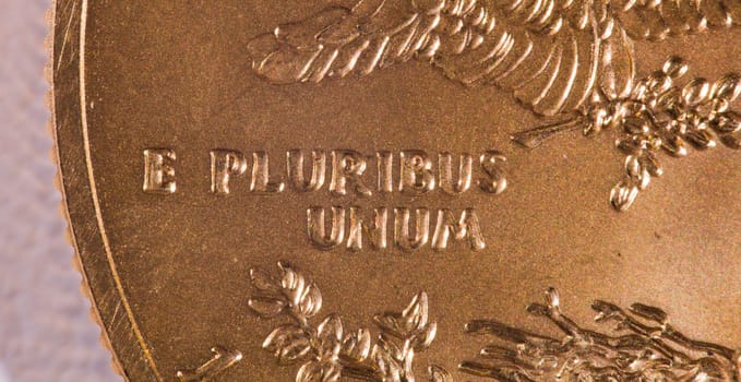 Gold Eagle one ounce coins with macro shot of the engraving of E Pluribus Unum