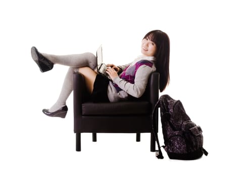 Chinese student working on a laptop while sitting in a leather chair.
