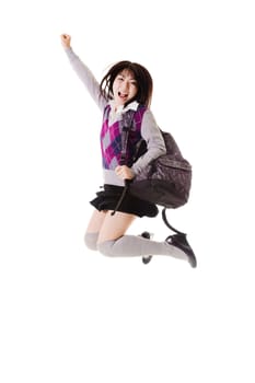 Female Chinese student with a backpack on a white background jumping in the air.
