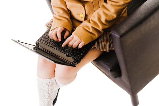 Closeup of a female Chinese student working on a laptop while sitting in a leather chair.