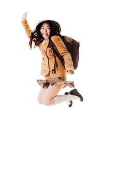 Female Chinese student wearing a backpack on a white background jumping into the air.