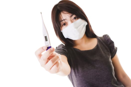 Closeup of a sick Chinese woman wearing a face mask holding a digital thermometer.