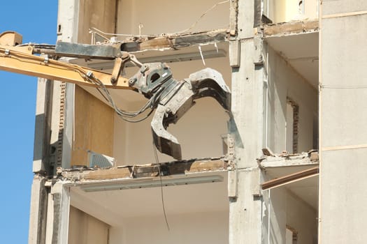 Excavator demolishing a high-rise building