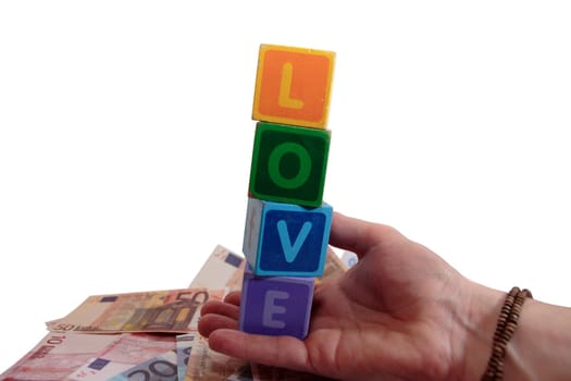 childrens toy letters in outstretched hands against white background and cash spelling love