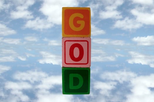 childrens toy letter building blocks against a cloudy background spelling god with clipping path