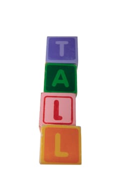 childrens toy letter building blocks against a white background spelling tall with clipping path