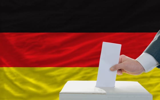 man putting ballot in a box during elections in germany