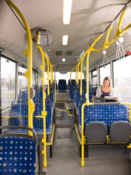 Lonely woman on the bus reading a newspaper