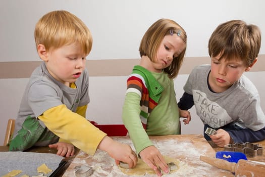 Children cut out cookies for Christmas