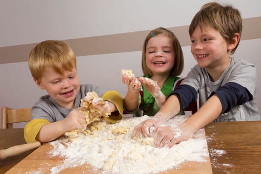 Children knead dough and have a lot of fun