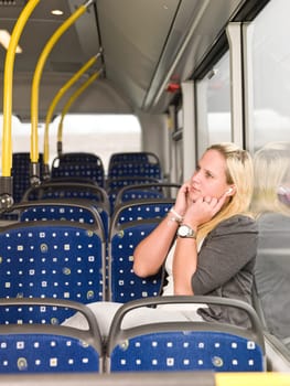 Young woman alone on the bus listen to music