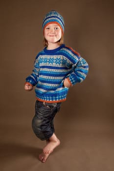 child in sweater or knit wear. cute blonde boy with long blond hair on retro brown background