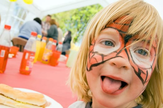 face paint on child at birthday party celebration. boy kid pretend to be tiger or spideman