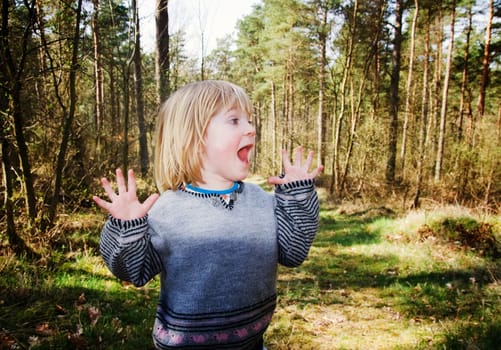 Child in forest looking scared or surprised. boy in wood with curious expression