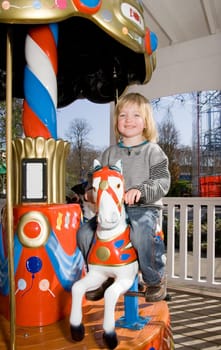 Child on merry-go-round horse carousel. happy child on ride in fairground park