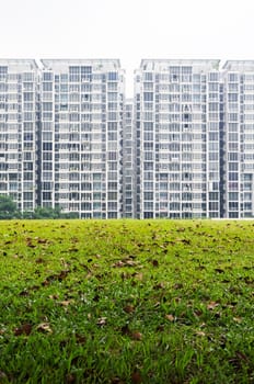 condominium housing with green grass field foreground.