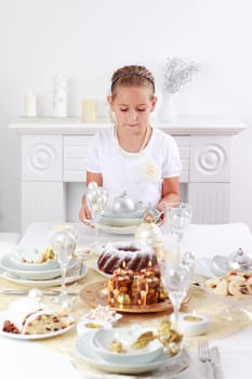 Cute girl setting table for Christmas