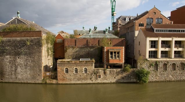 industrial buildings by river or canal. apartment development next to old factory buildings by the water