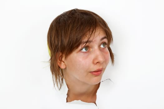 Young woman looking out of white paper