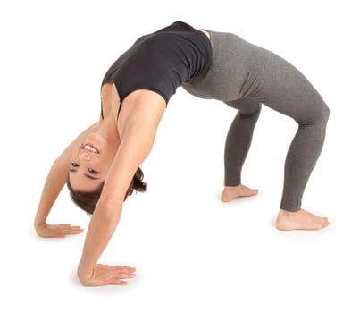 A young woman is doing the bridge pose.