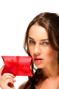 Beautiful woman holding red gift to her face on white background