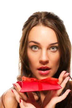 Beautiful woman with wide open eyes holding gift on white background