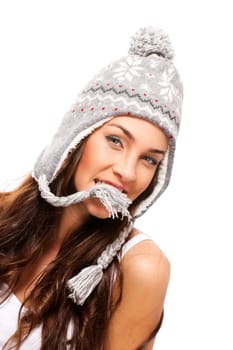 Beautiful brunette woman holding part of her winter hat in mouth on white background