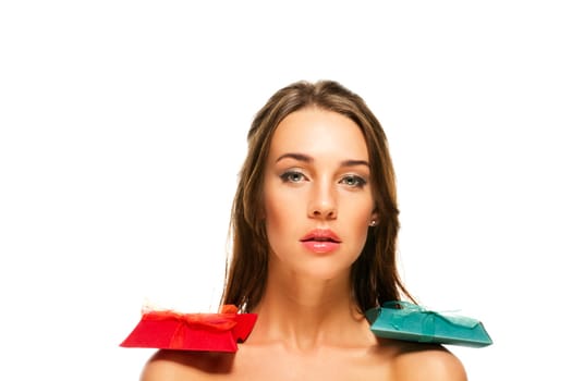 Beautiful brunette woman with gifts on shoulders on white background