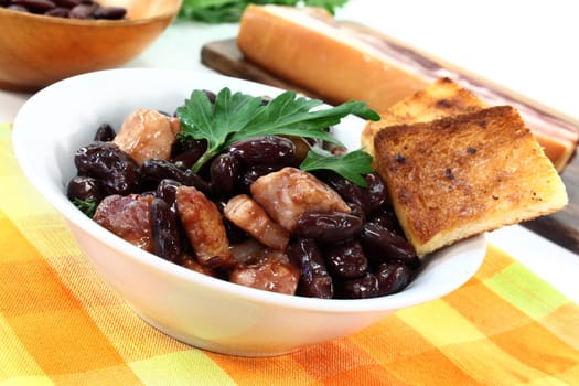 a bowl of kidney beans,parsley and fried bacon