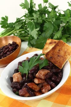 a bowl of kidney beans,parsley and fried bacon