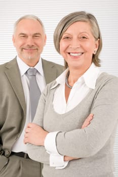 Professional elegant smiling senior businesspeople standing with cross arms
