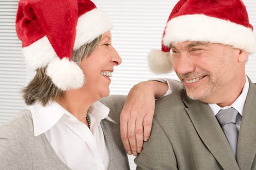 Laughing senior businesspeople having fun with Xmas Santa hat