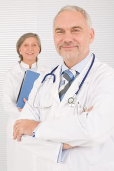 Medical doctor team mature woman and senior man holding folders