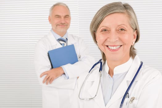 Medical doctor team mature woman and senior man holding folders
